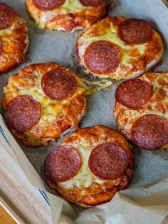 small pepperoni pizzas sitting in a cardboard box