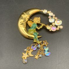 Vintage Kirks Folly Pipedream Fairy Trumpet Moon Stars Bubbles Charm Rhinestone Pin Brooch Detachable Charm This Vintage Kirks Folly Brooch Is A Dreamy Accessory For Any Occasion. The Moon-Shaped Brooch Features Aurora Borealis Bubbles Rhinestones And A Detachable Charm For Added Whimsy. The Gold-Colored Acrylic And Metal Enamel Construction Adds To Its Fairy-Tale Charm. This Brooch Is Signed By The Brand And Is A Unique Piece Of Original Vintage Jewelry. It Would Make A Perfect Addition To Any Fairy Moon, Kirks Folly Jewelry, Jewelry Nature, Kirks Folly, Colored Acrylic, Moon Stars, Aurora Borealis, Pin Brooch, Stars And Moon