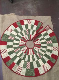 a red and green clock sitting on top of a piece of cloth