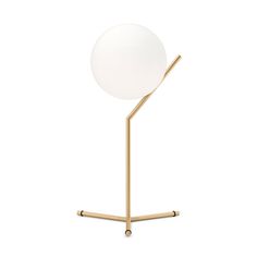 a white ball sitting on top of a metal stand next to a glass ball with gold legs