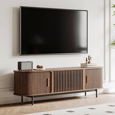 a flat screen tv mounted to the side of a wooden cabinet in a living room