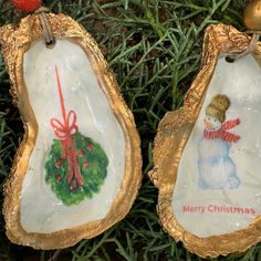 two christmas ornaments hanging from a tree with gold trimmings and decorations on them