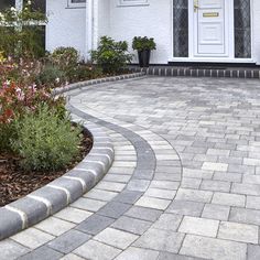 a brick walkway in front of a white house