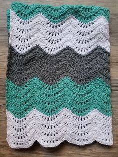 a crocheted blanket on top of a wooden table