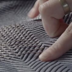 a person's hand on top of a piece of fabric