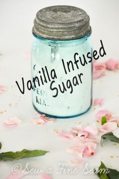 a jar filled with vanilla infused sugar sitting on top of pink flowers next to the words vanilla infused sugar