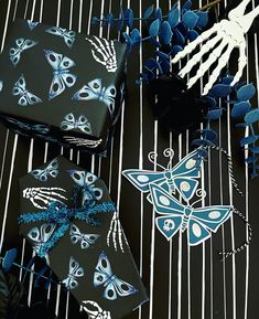 blue and black wrapping paper with butterfly designs on it, next to skeleton handprints