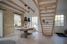 a dining room table with chairs under a stair case