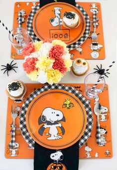 an orange and black place setting with cupcakes