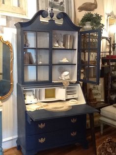 an old fashioned desk and hutch in a room with wood floors, white walls and blue furniture