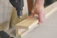 a person using a drill to cut wood