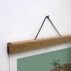 a wooden frame hanging on the wall with a small bird perched on top of it