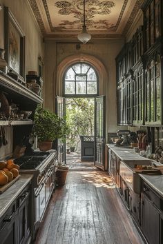 an old fashioned kitchen with wooden floors and black cabinets