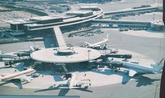 an airport with several planes parked at the gates and on the tarmac in front of it