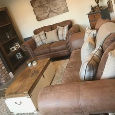 a living room with couches, chairs and a coffee table in front of a fireplace