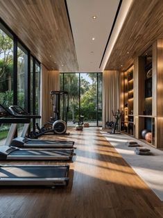 there are many treadmills in the room with glass walls and floor to ceiling windows