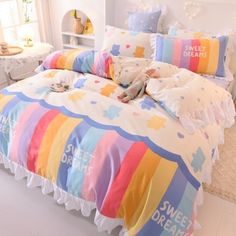 a bed with colorful comforters and pillows on it