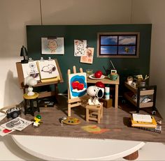 a doll house with furniture and pictures on the wall, including a desk and chair