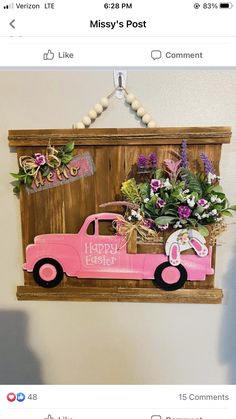 a pink truck with flowers in the back is hanging on a wooden sign that says happy easter