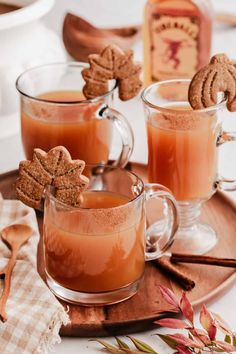 two mugs filled with liquid and cinnamon cookies