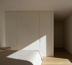 a bedroom with white walls and wooden floors