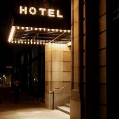 the hotel sign is lit up at night