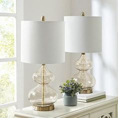 two lamps sitting on top of a white table