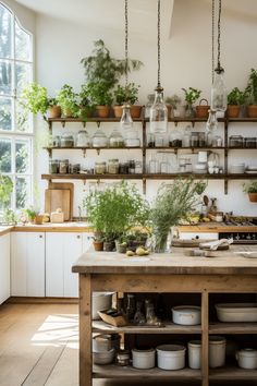 a kitchen filled with lots of pots and pans on shelves next to a window