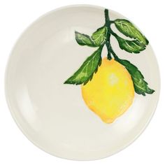 a white plate with a yellow lemon painted on the side and green leaves around it