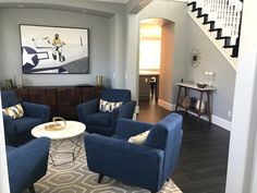 a living room filled with furniture and a painting on the wall above it's doorway