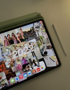 an iphone with pictures on the screen and a pen next to it, sitting on top of a table