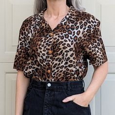 "90's rayon button-front shirt. Black and brown animal print, with wooden buttons. Machine washable. Tagged as an XL, measurements below. Shown on a S. Excellent condition. 1980's-era black denim skirt seen in the pictures is also available on my other listings. Shoulders: 18.5\" Sleeves: 9\" Chest: 23\" PTP Length: 27\""