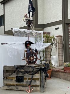 a pirate ship made out of wooden pallets on the side of a building with a skeleton hanging from it's roof