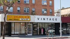 an old fashion store on the corner of a street in front of a brick building