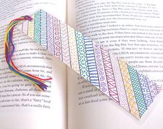 an open book with a colorful ribbon on it's cover and the pages are folded in half