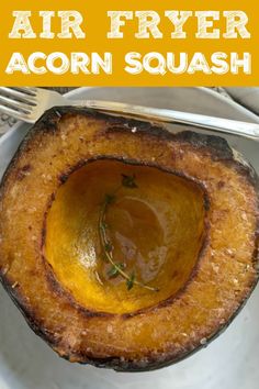 an air fryer acorn squash on a white plate with a fork and knife