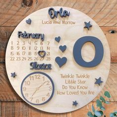 a wooden clock with the date and time on it, surrounded by blue hearts and stars