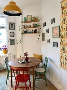 a dining room table with two chairs next to it and shelves on the wall above