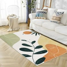 a living room with a white couch and colorful rugs on the hardwood flooring