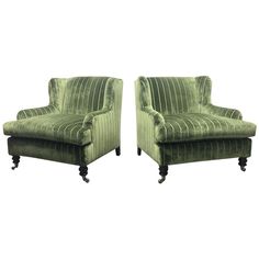 a pair of green chairs sitting next to each other on top of a white background