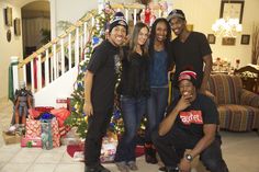 a group of people standing in front of a christmas tree