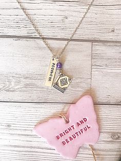 two necklaces that say bright and beautiful, one has a pink heart on it