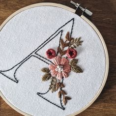 a floral monogram on a white embroidery hoop