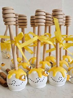 there are some candy apples with yellow icing on them and wooden spoons in the background