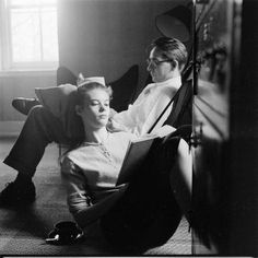 an old black and white photo of a woman laying on the floor next to a man