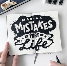 two hands holding an open notebook with the words making mistakes is part of life written on it