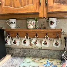 coffee mugs are hanging on the kitchen counter