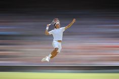 a tennis player jumping in the air with his racket