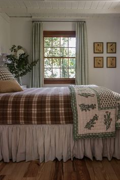 a bed sitting under a window in a bedroom next to a wooden floor and wall