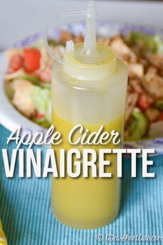 an apple cider vinaigrete sits next to a plate of food